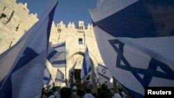 Warga Israel membawa bendera selama pawai menandai Hari Yerusalem di dekat Gerbang Damaskus di luar Kota Tua Yerusalem 17 Mei 2015. (Foto: dok).