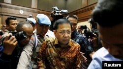 Policeman guards as former Indonesian parliament speaker Setya Novanto (C) attends court for his verdict in Jakarta, Indonesia, April 24, 2018.