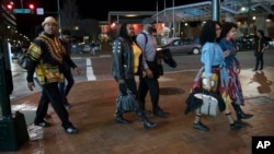 FILE - Emanuel Lawton, left, and his family dressed in Wakanda-inspired attire arrive to see Black Panther in Silver Spring, Maryland, Feb. 15, 2018. Just as "Black Panther" is setting records at the box office, a new study finds that diverse audiences are driving most of the biggest blockbusters and many of the most-watched hits on television. UCLA's Bunche Center released its fifth annual study on diversity in the entertainment industry Tuesday, Feb. 27, unveiling an analysis of the top 200 theatrical film releases of 2016 and 1,251 broadcast, cable and digital platform TV shows from the 2015-2016 season.