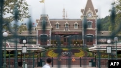A security guard checks a empty square usually filled with visitors at Hong Kong Disneyland in Hong Kong on Jan. 26, 2020, after the park announced it was shutting its doors until further notice over a deadly virus outbreak in central China. 