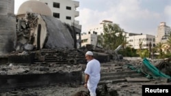 A Palestinian man looks at a mosque in Gaza City which police said was hit in an Israeli air strike.