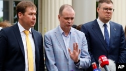 El abogado ruso Ivan Pavlov, centro, habla con los medios mientras los abogados Ilya Novikov (izquierda) y Vladimir Voronin (derecha) escuchan frente a Tribunal de Moscú en Moscú, 9 de junio de 2021. Dicho tribunal proscribió las organizaciones fundadas p
