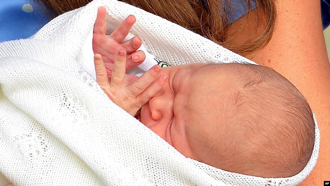 Kate, the Duchess of Cambridge, carries her newborn son, His Royal Highness Prince George of Cambridge, into public view for the first time outside St. Mary's Hospital in London, July 23, 2013. 