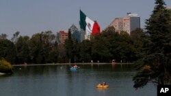 FILE - Paddle boaters make their way around a lake in the Chapultepec Park in Mexico City, Nov. 19, 2012. Chapultepec is a park divided between shady stretches of forest and more-developed plazas, fountains and sculpture gardens.