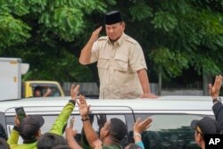 FILE — Indonesian Defense Minister and presidential frontrunner Prabowo Subianto greets supporters after visiting his father's grave in Jakarta, Indonesia February 15, 2024.