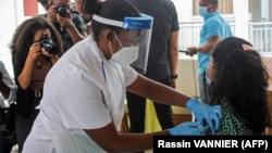 A medical personel injects the first dose of the Chinese Covid-19 vaccine produced by Sinopharm at the Seychelles Hospital in Victoria, on January 10, 2021. 