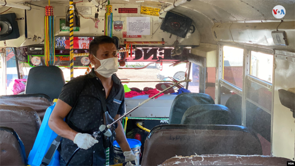 Un empleado de un servicio de limpieza fumiga un autobús de una de las cooperativas de transporte en Managua. [Foto: Houston Castillo]