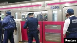 Polisi menyelidiki tempat kejadian setelah insiden penyerangan di jalur kereta di Tokyo, Jepang, 31 Oktober 2021 dalam gambar yang diperoleh dari video di media sosial. (TWITTER / @SIZ33/via REUTERS)