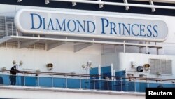 Seorang penumpang mengenakan masker di dek kapal pesiar Diamond Princess di Terminal Kapal Pesiar Daikoku, Yokohama, Jepang, 13 Februari 2020. (Foto: Reuters)