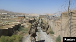 FILE - U.S. military advisers from the 1st Security Force Assistance Brigade walk at an Afghan National Army base in Maidan Wardak province, Afghanistan August 6, 2018.