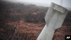 FILE - In this Sunday Jan. 6, 2013 photo, an unexploded bomb lies half-buried in the ground in Taftanaz, Syria. 