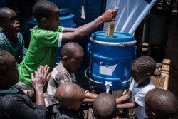Children learn how to wash their hands to help prevent COVID-19 as local NGO Shining Hope for Communities installs hand-washing stations at Kibera slum in Nairobi, March 18, 2020.
