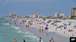 Beachgoers take advantage of the sun, sand, and surf as they spend time on Clearwater Beach, March 2, 2021, in Clearwater, Fla., a popular spring break destination, west of Tampa.