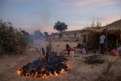 A man lights a fire to make dinner for his family in the Um Rakouba refugee camp in Qadarif, eastern Sudan, Dec. 14, 2020.