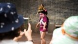 Visitors take photos of a child dressed in a traditional costume before a folk performance in Panyu, Guangdong province, China.