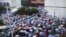 Local residents gather in front of a municipal government building in Shifang county, Sichuan province, in this handout picture taken July 2, 2012. 