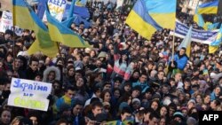 Students hold placards and flags as thousands rally in the western Ukrainian city of Lviv during a rally of pro-European supporters, Nov. 27, 2013.