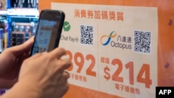 FILE - A shopper scans a QR code to redeem a shopping voucher at a mall in Hong Kong on Aug. 1, 2021.