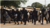 Des policiers essaient de stopper la marche qui se dirige evrs l'autoroute, lors d'une manifestation à Conakry, en Guinée, le 22 mars 2018. (VOA/Zakaria Camara)