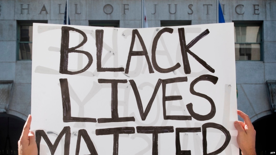A supporter of Black Lives Matter holds a sign during a protest outside the Hall of Justice as they demonstrate against the death of George Floyd, in Los Angeles, California, on June 10, 2020. 