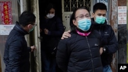 District councillor and lawyer Daniel Wong Kwok-tung, center, is escorted by police outside his office in Hong Kong, Jan. 14, 2021.