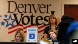 FILE - An election judge helps a voter with a question about the ballot at the Denver Elections Division, in Denver, Colorado, Nov. 6, 2018. 