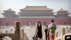 Visitors wearing face masks to protect against the new coronavirus walk through the Forbidden City in Beijing, Friday, May 1, 2020. The Forbidden City reopened beginning on Friday, China's May Day holiday, to limited visitors after being closed to…