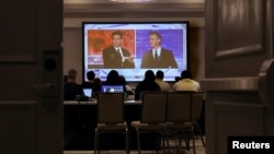 Журналисты наблюдают за дебатами губернатора Флориды Рона Десантиса с губернатором Калифорнии Гэвином Ньюсомом на экране в медиа-зале в Альфаретте, штат Джорджия, США, 30 ноября 2023 года.