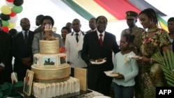 Presiden Zimbabwe Robert Mugabe (keempat dari kanan) dan ibu negara Grace Mugabe (kedua dari kanan) dalam pesta ulang tahun di istana negara. (AFP/Jekesai Njikizana)