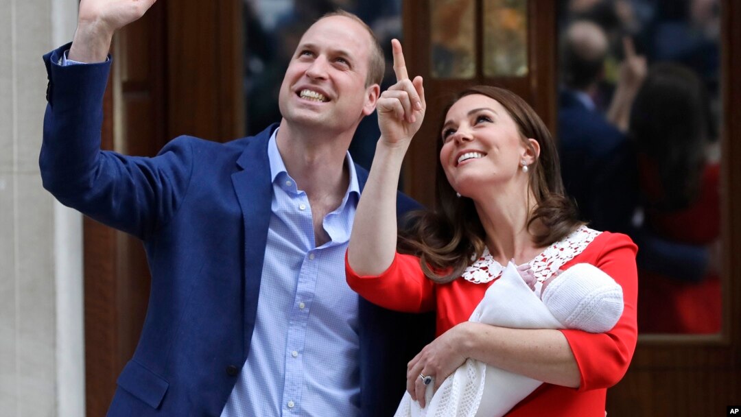 Pangeran William bersama Kate, Duchess of Cambridge, membawa bayi mereka keluar dari rumah sakit St Mary's di London, Inggris hari Senin (23/4). 