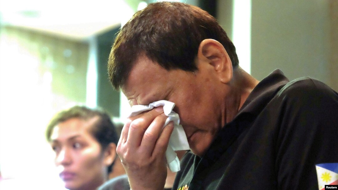 Presiden Rodrigo Duterte menangis saat ia menghibur anggota keluarga korban kebakaran di kota Davao di Filipina, 24 Desember 2017.