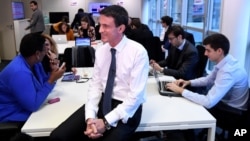 Former French Prime Minister Manuel Valls, now the candidate for the socialist party primary election, smiles during the inauguration of his campaign headquarters, Dec. 14, 2016, in Paris. French officials are working to secure the election from cyberattacks.