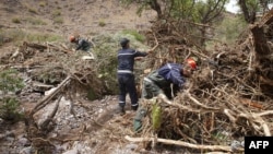 Des membres de la défense civile marocaine à la recherche de victimes sur les lieux d'une inondation lorsqu'un fleuve a débordé de son lit et inondé le terrain de football du village de Tizert, dans le sud du Maroc, dans la région de Taroudant, le 29 août 2019.