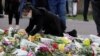 Una mujer coloca una ofrenda floral afuera del Castillo de Windsor en Windsor, Inglaterra, el domingo 11 de abril de 2021, en honor del príncipe Felipe, esposo de la reina Isabel II. 