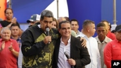 El presidente venezolano Nicolás Maduro y el hombre de negocios -el colombiano Alex Saab- se abrazan durante un evento por el aniversario del golpe de Estado de 1958 que derrocó al dictador Marcos Pérez Jiménez, en Caracas, Venezuela, el 23 de enero de 2024. 