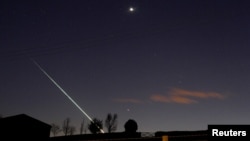 FILE - A meteorite creates a streak of light across the night sky over the North Yorkshire moors at Lealholm, near Whitby, northern England, April 26, 2015. 