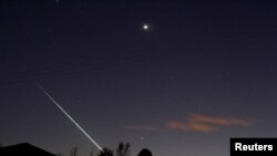 FILE - A meteorite creates a streak of light across the night sky over the North Yorkshire moors at Lealholm, near Whitby, northern England, April 26, 2015. 