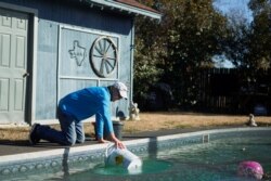 Rodney Roberts llena un balde con agua de su piscina para llenar los inodoros de su casa después de que el clima invernal provocara cortes de agua en Mineral Wells, Texas, EE. UU. El 20 de febrero de 2021.