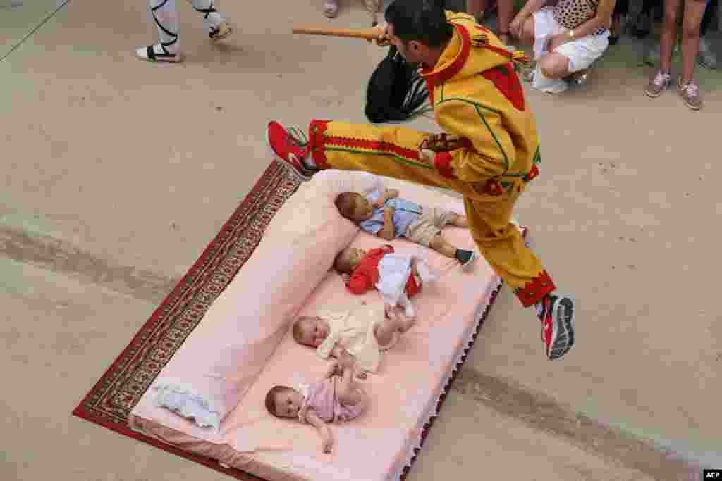 The "Colacho", a character that represents the devil, jumps over babies lying on a mattress in the street during 'El Salto del Colacho' (The Devil's Jump) festival, in the village of Castrillo de Murcia, near Burgos, Spain, June 23, 2019.