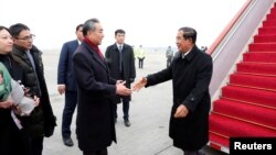 Chinese State Councilor and Foreign Minister Wang Yi welcomes Cambodian Prime Minister Hun Sen as he arrives at the Beijing Capital International Airport in Beijing, China February 5, 2020. 