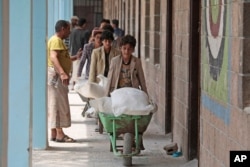 Displaced Yemenis receive food supplies provided by the World Food Program, at a school in Sana'a, Aug. 25, 2019.