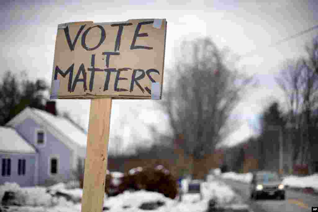 A handmade sign stuck in a snowbank on a rural road urges citizens to vote in Searsmont, Maine, Nov. 4, 2014. 