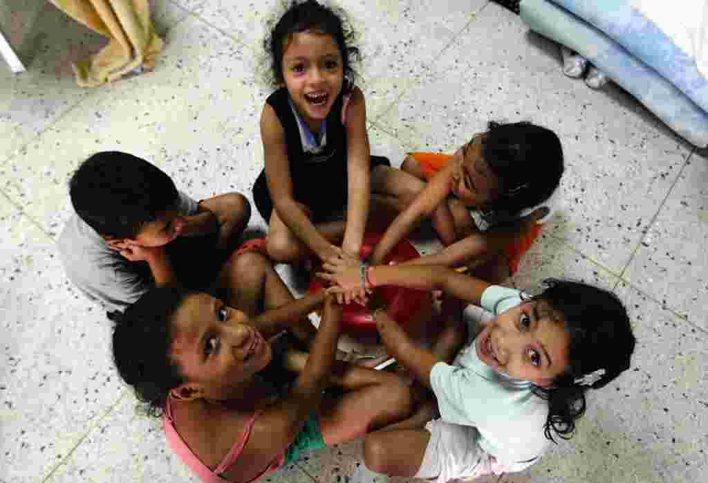 Children play in a makeshift shelter after losing their homes to weeks of rain in Caracas. More than a dozen people have died and thousands have been forced from their houses after weeks of downpours in Venezuela that have caused flooding and mudslides. 
