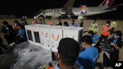 Workers move boxes loaded with COVID-19's vaccine before a handing over ceremony at Phnom Penh International Airport, in Phnom Penh, Cambodia, Tuesday, March 2, 2021. More than 300,000 doses of AstraZeneca COVID-19 vaccines from Serum Institute of…