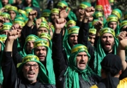 FILE - Lebanese Shi'ite supporters of the Iranian-backed Hezbollah group shout slogans as they march in a southern suburb of Beirut, Lebanon, Oct. 12, 2016.