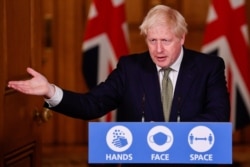 FILE - Britain's Prime Minister Boris Johnson gestures as he speaks during a virtual news conference at Downing Street, London, Oct. 12, 2020.