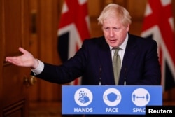 FILE - Britain's Prime Minister Boris Johnson gestures as he speaks during a virtual news conference at Downing Street, London, Oct. 12, 2020.