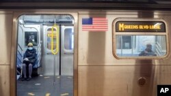 Pasajeros con mascarillas en un tren de la ruta M en Nueva York, el viernes 10 de abril de 2020.