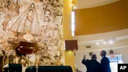 Presiden Barack Obama belajar tentang gereja “Shrine of Our Lady of Charity” dari Pastor Juan Rumin Dominguez dalam kunjungan mendadak di Miami (28/5). (AP/Pablo Martinez Monsivais)