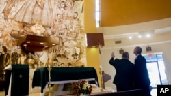 President Barack Obama learns about the Shrine of Our Lady of Charity from Father Juan Rumin Dominguez during an unannounced stop at the Miami church, May 28, 2015.